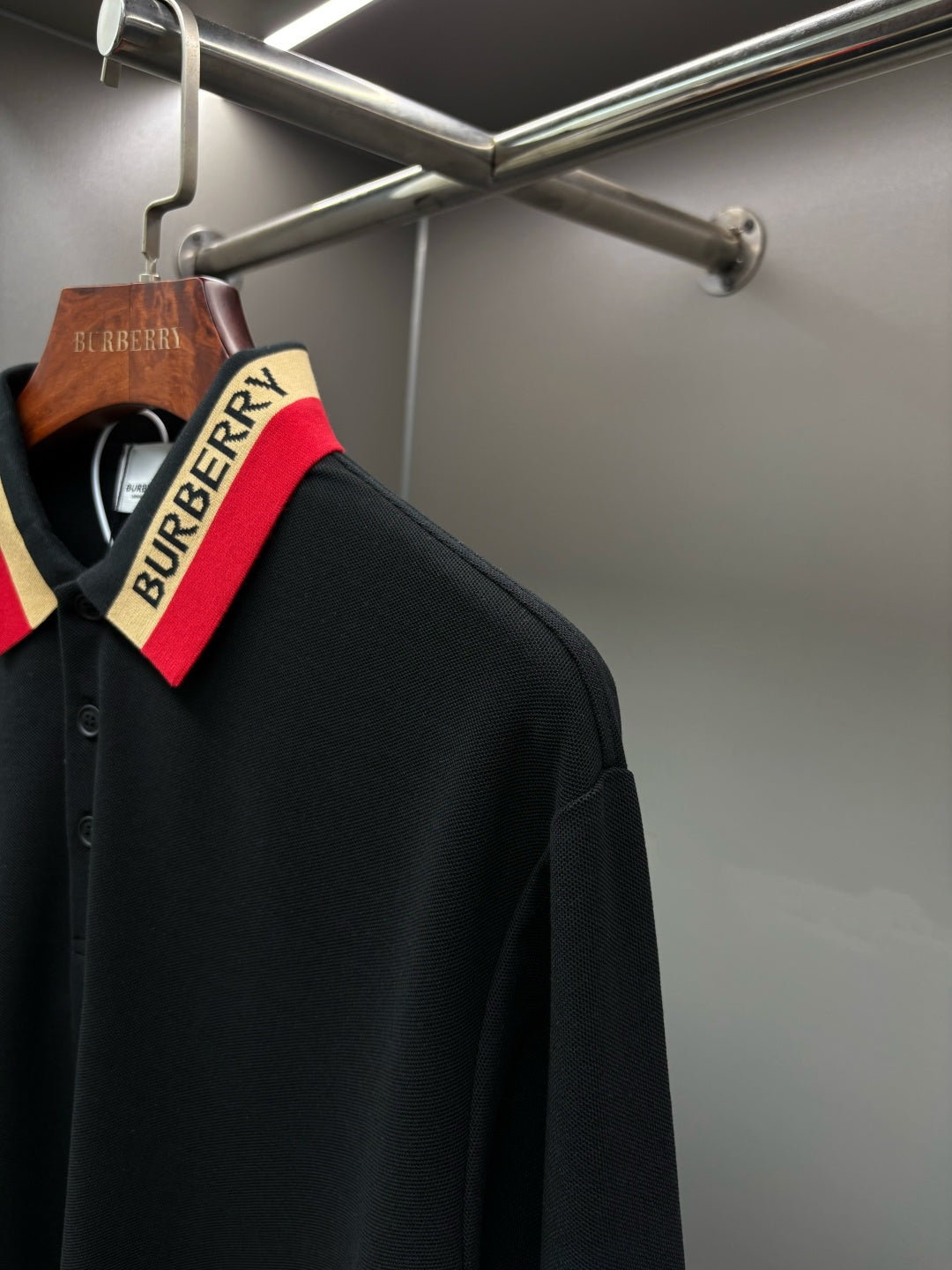 Black long-sleeve polo shirt with striped collar and button placket