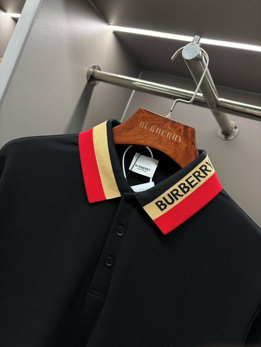 Black long-sleeve polo shirt with striped collar facing and buttoned placket