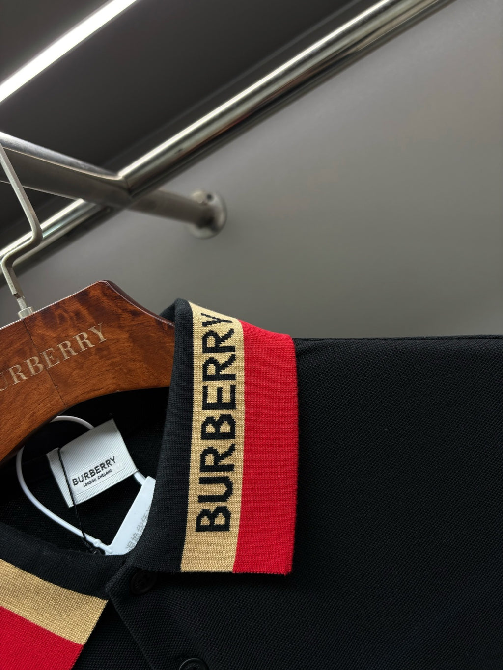 Polo shirt collar detail with Burberry logo and red, gold, white stripe trim