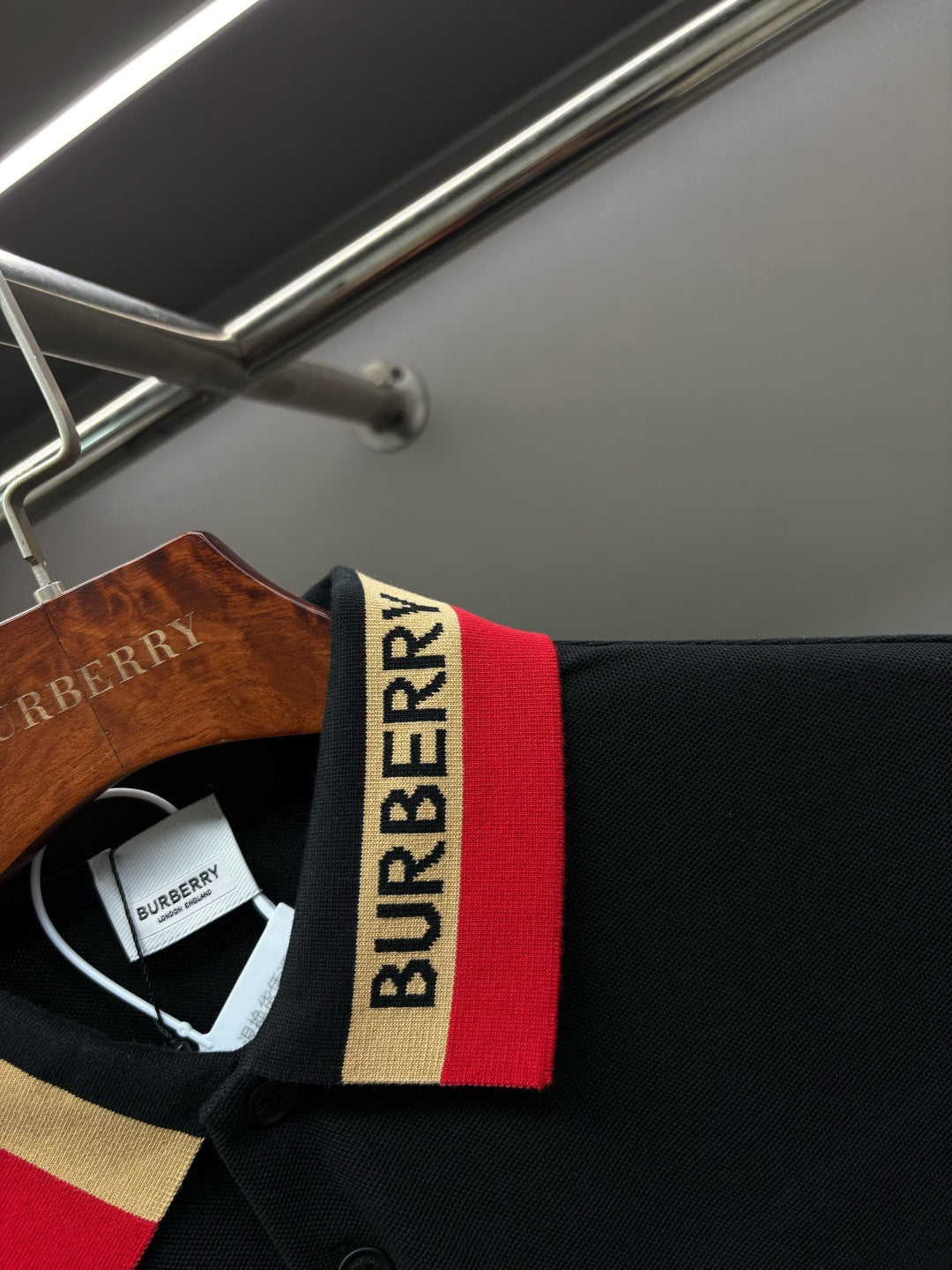 Polo shirt collar detail with Burberry logo and red, gold, white stripe trim
