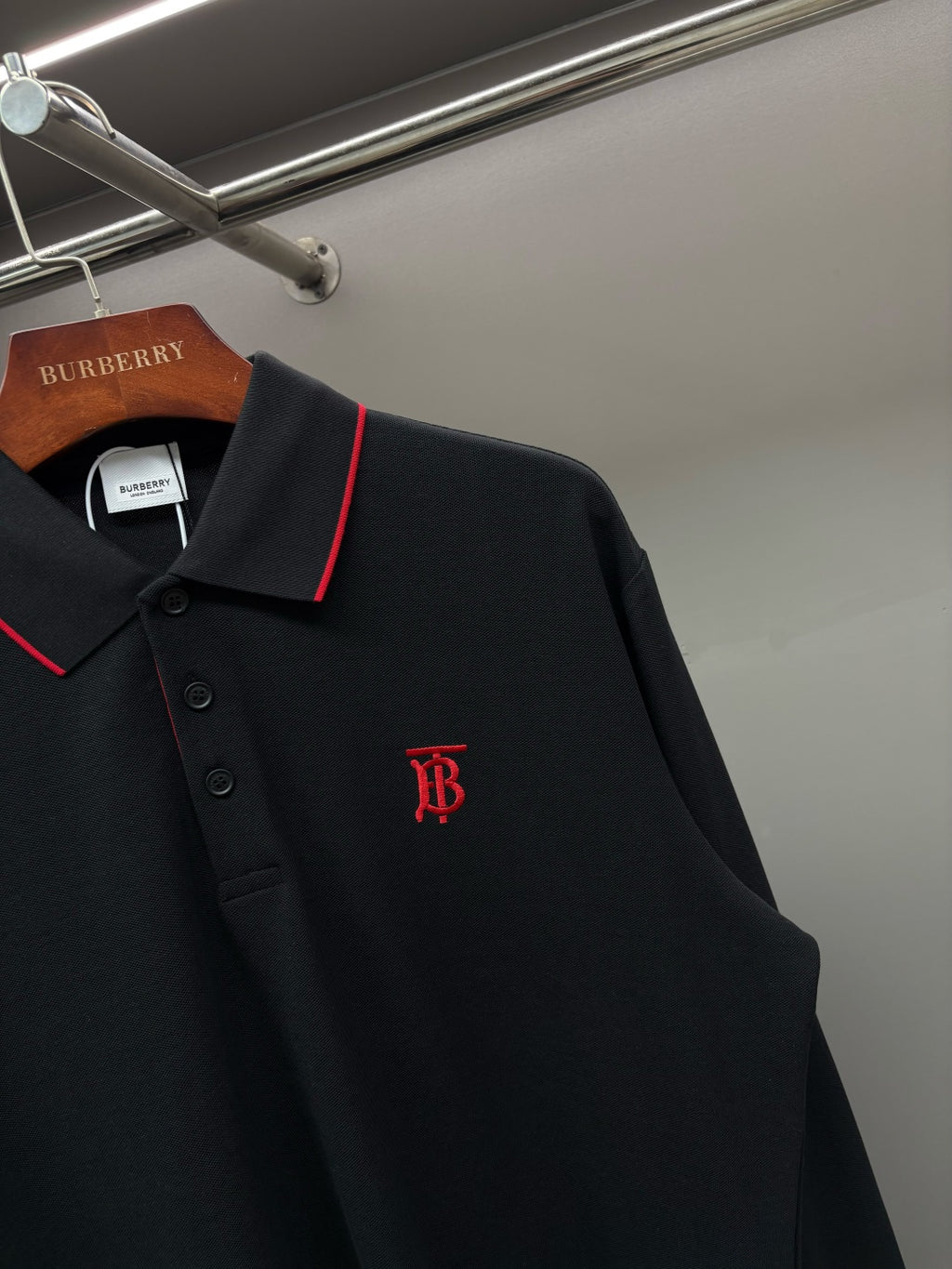 Long-sleeve polo shirt close-up: red-trim collar and front monogram logo