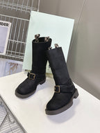 Pair of black suede mid-calf boots with buckled straps and rubber lug sole