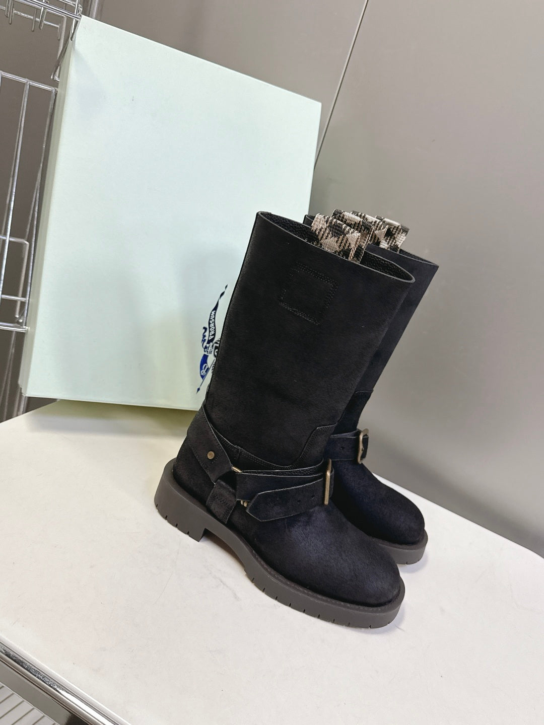Black suede mid-calf boots with buckled strap and low lug sole