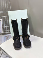 Pair of black suede ankle boots with side buckle and short stacked heel