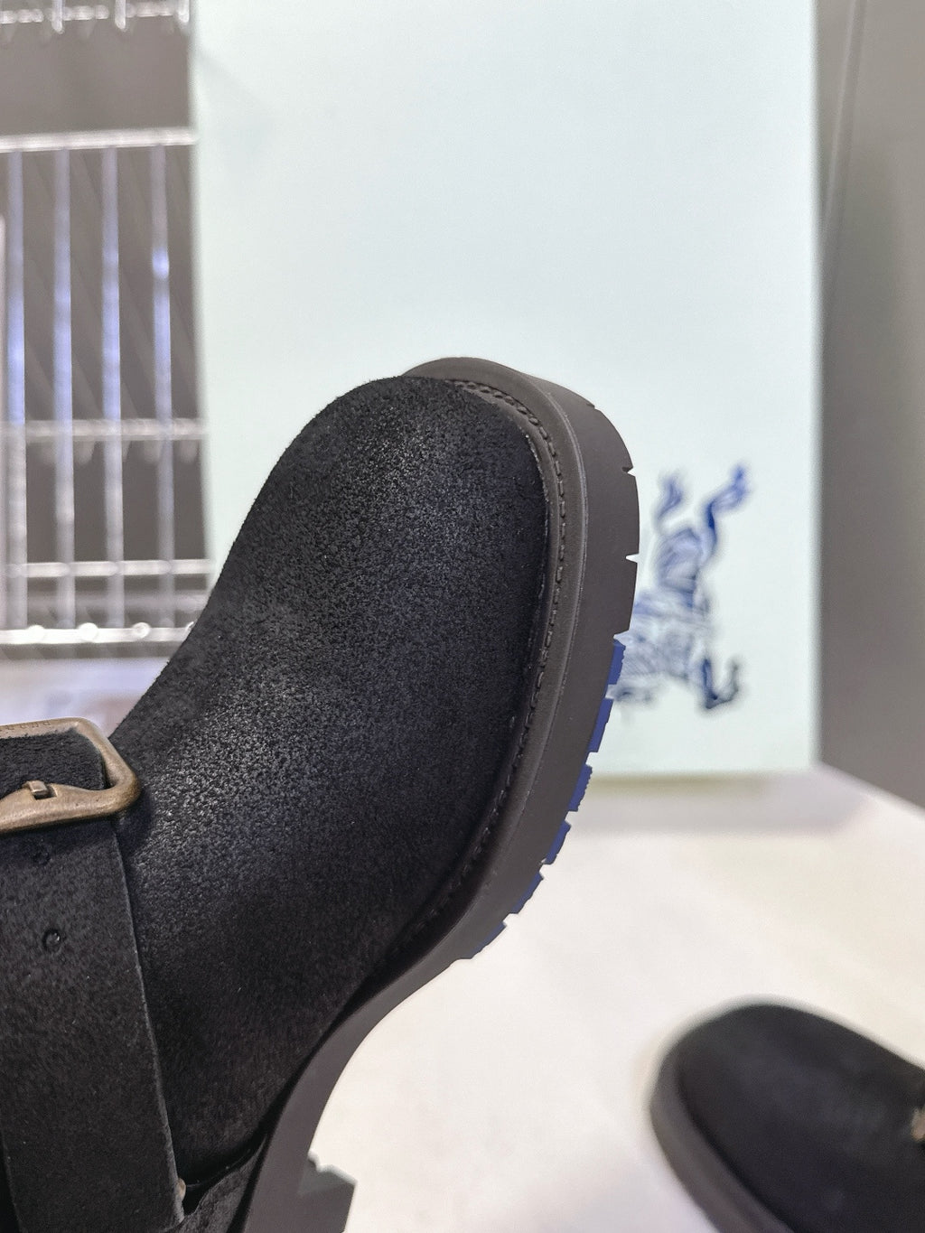 Black suede boot toe with stitched trim and low rubber sole