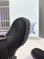 Black suede boot toe with stitched trim and low rubber sole