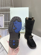 Black boot outsoles with blue tread pattern and dark rubber sole