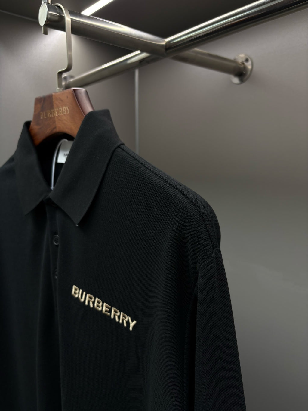 Black Burberry long-sleeve polo shirt with chest logo on hanger
