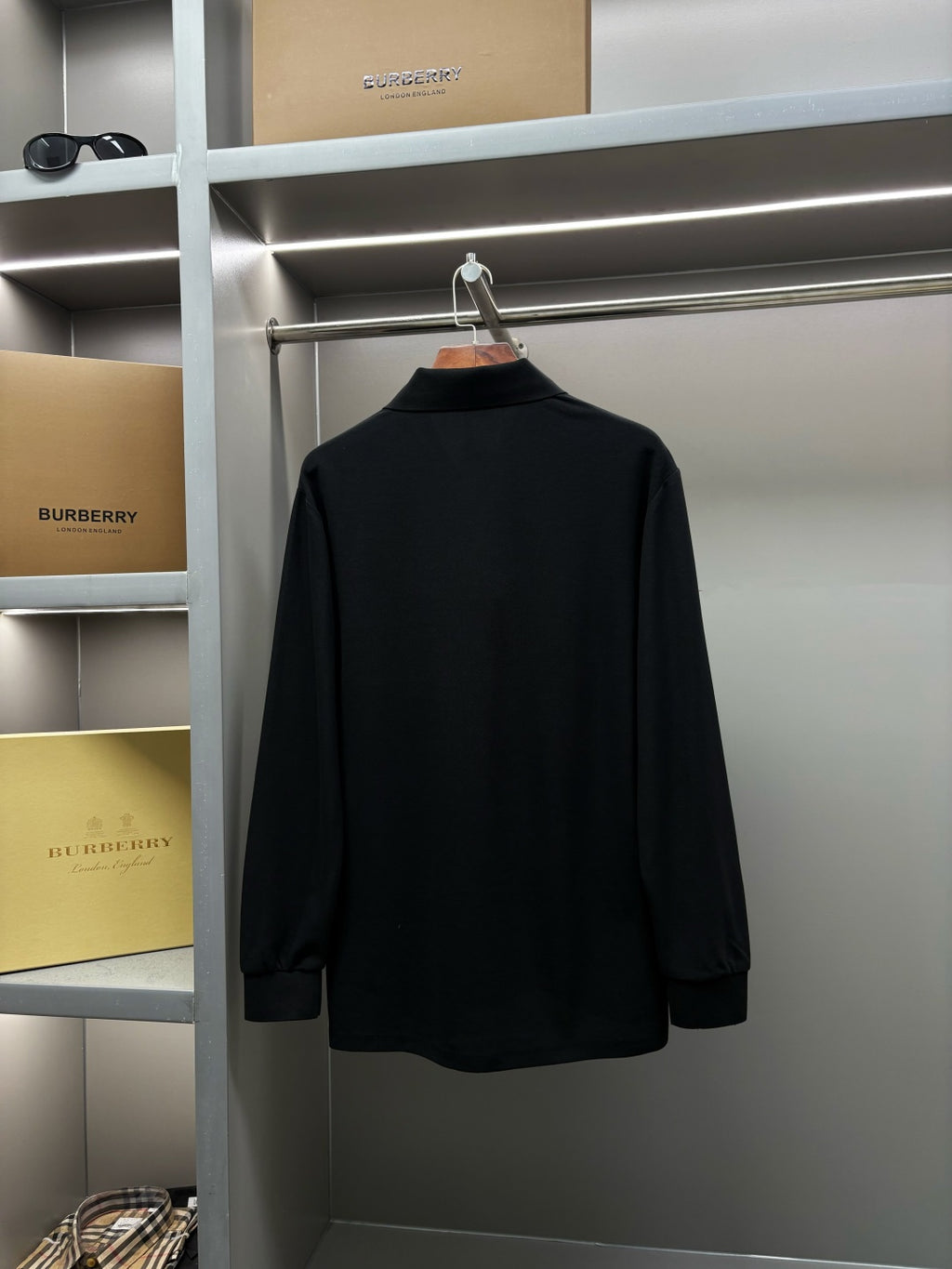 Black Burberry long-sleeve polo shirt back view on hanger