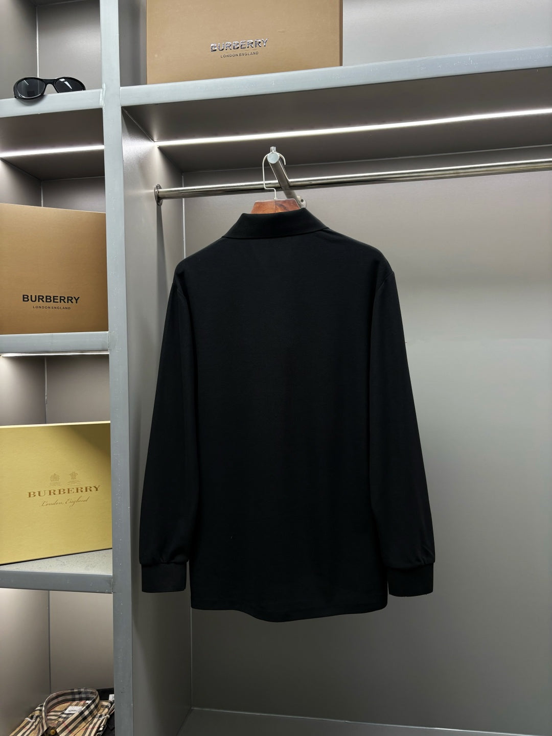 Black Burberry long-sleeve polo shirt back view on hanger