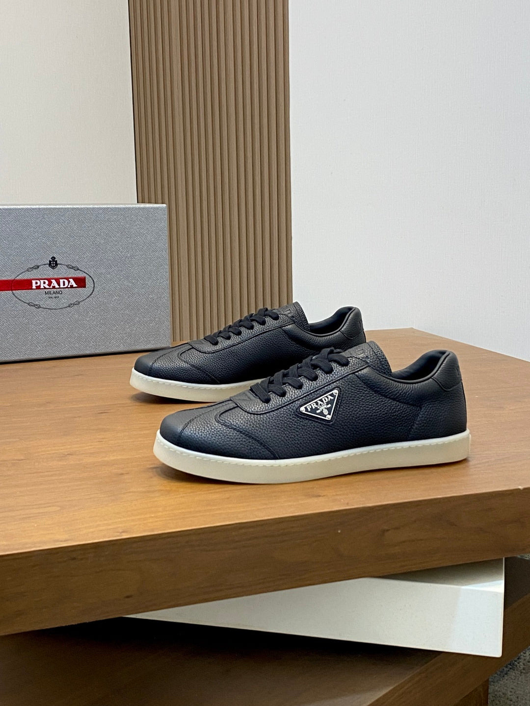 Prada unisex low-top sneakers pair, dark navy leather, lace-up, logo tongue patch