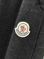 Moncler logo patch on dark grey sweatpants, stitched round emblem
