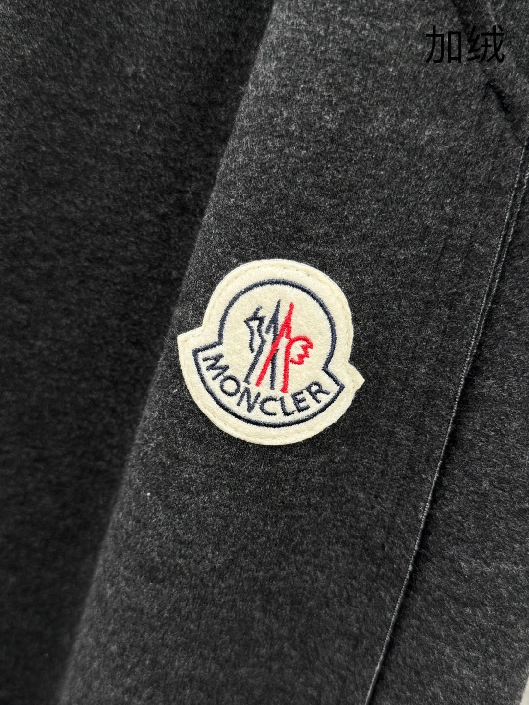 Moncler logo patch on dark grey sweatpants, stitched round emblem