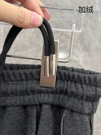 Elastic waistband with metal clasp and drawstring cord on dark grey sweatpants