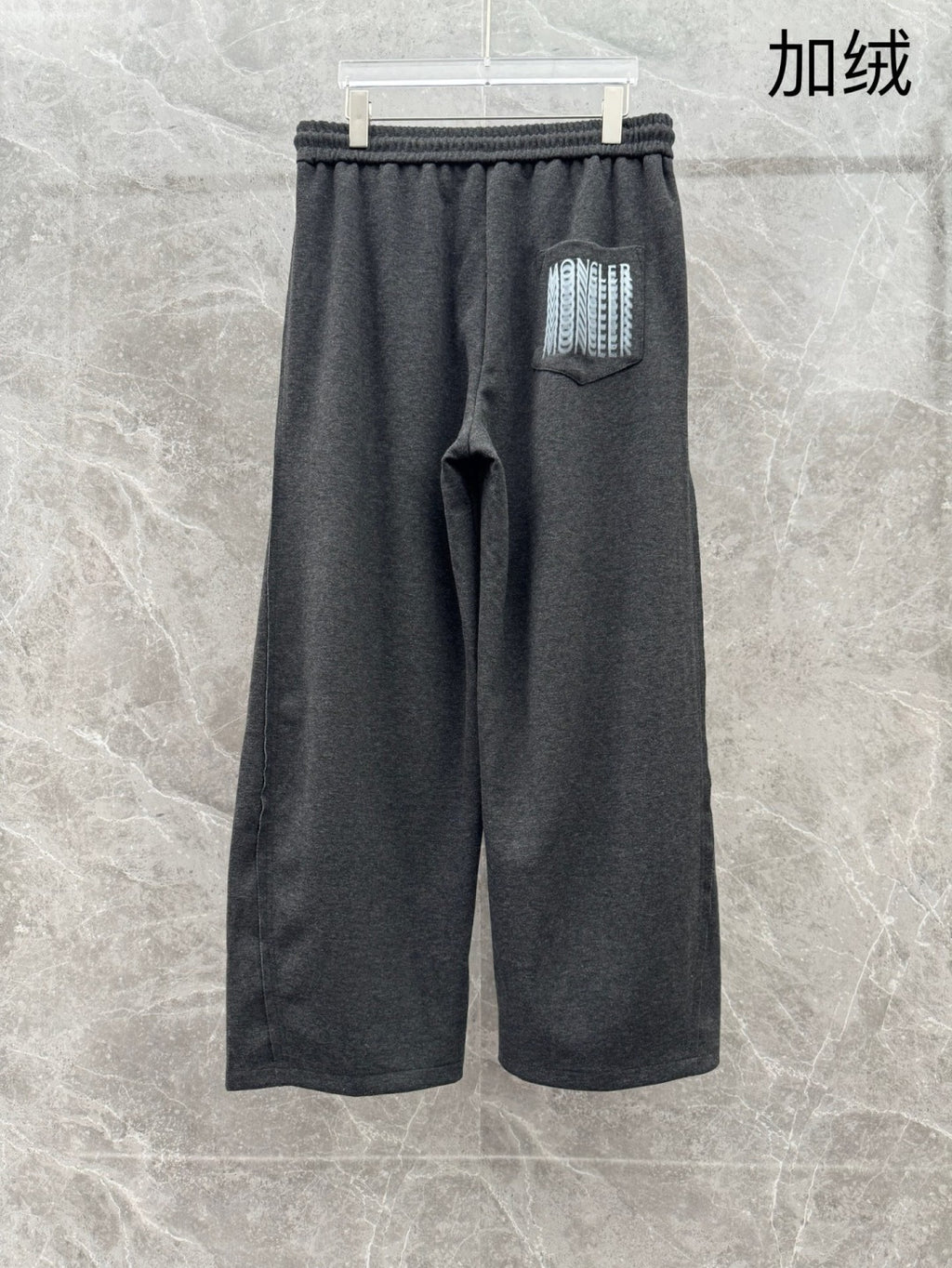 Dark grey sweatpants with elastic waistband, side pocket logo patch, relaxed fit