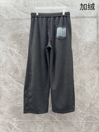 Dark grey sweatpants with elastic waistband, side pocket logo patch, relaxed fit