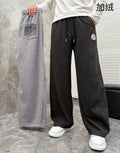 Pair of jogger pants, dark charcoal and black, elastic waistband, side pockets