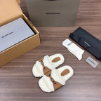 White teddy Balenciaga sandals with tan strap panel and buckle accents, angled view