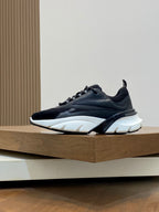 Black chunky Dior sneakers, side profile with white sole and lace-up closure
