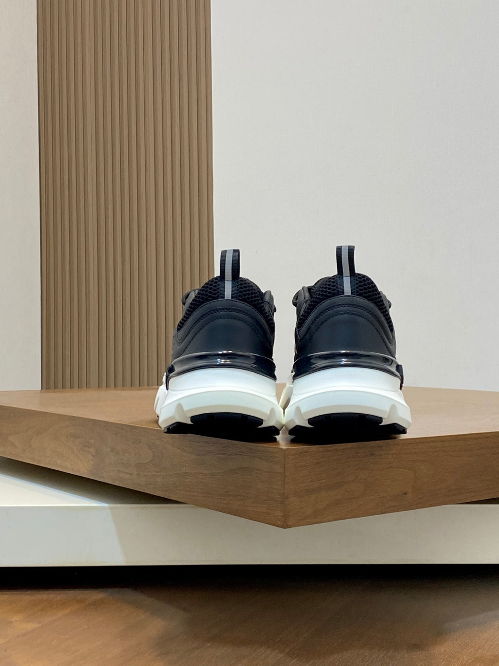 Black Dior sneakers, back view with chunky white sole and rear pull tab