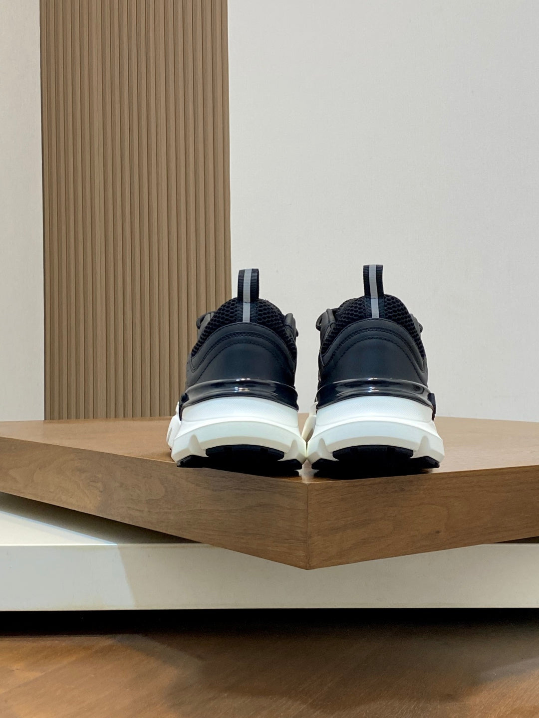 Black Dior sneakers, back view with chunky white sole and rear pull tab