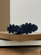 Dior sneaker outsoles, dark tread with light rubber edges, pair shown from below