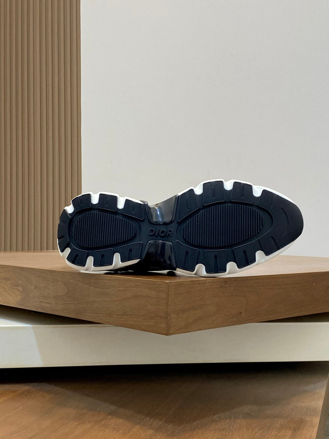 Dior sneaker outsoles, dark tread with light rubber edges, pair shown from below