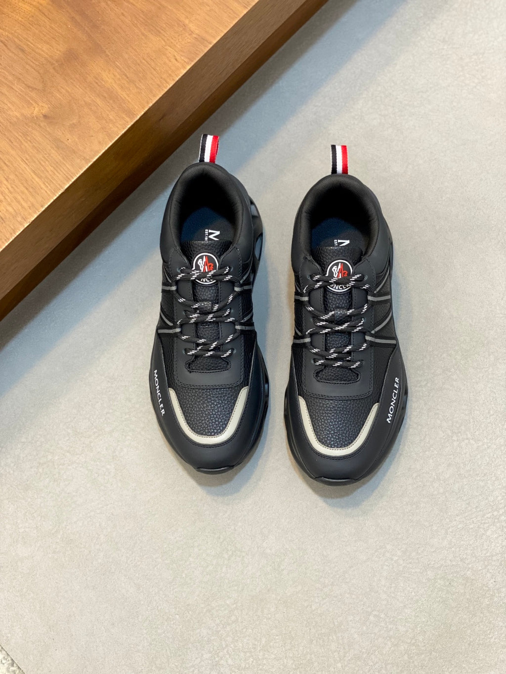 Moncler black low-top sneakers with red-white heel tab and chunky rubber sole