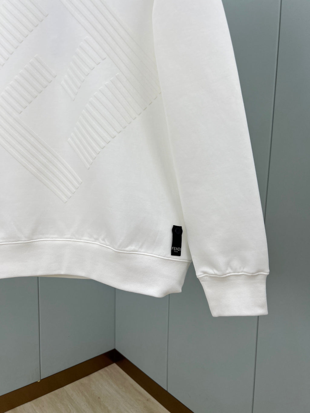 White Fendi sweatshirt sleeve with ribbed cuff and small logo tag at hem