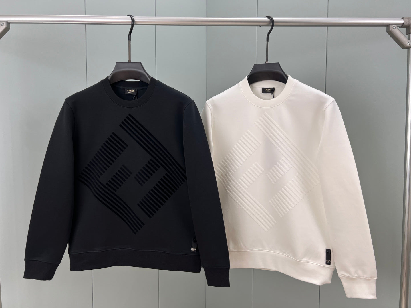 Black and white Fendi sweatshirts with raised diagonal logo patterns on front