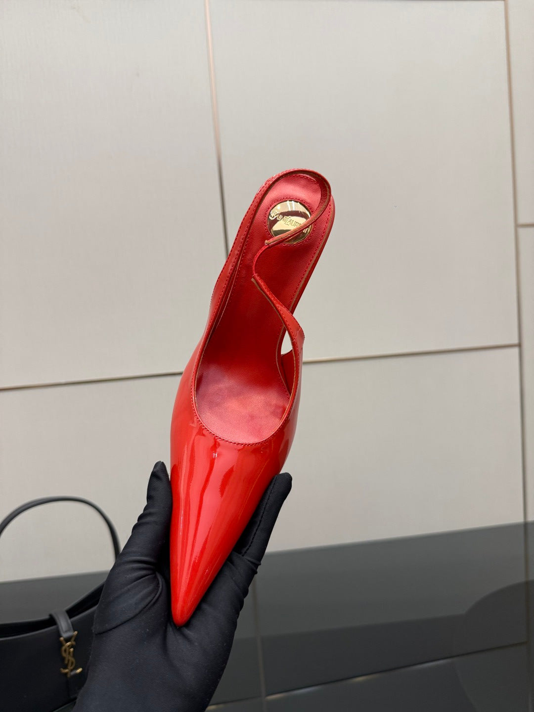 Red patent pointed-toe stiletto slingback heel with gold logo on insole