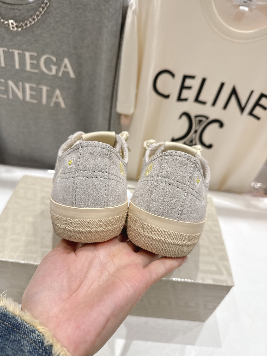 Pair of grey low-top sneakers, back view, beige rubber soles, lace-up front