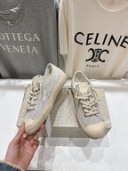 Grey low-top sneakers with gold star accents and white laces, beige sole