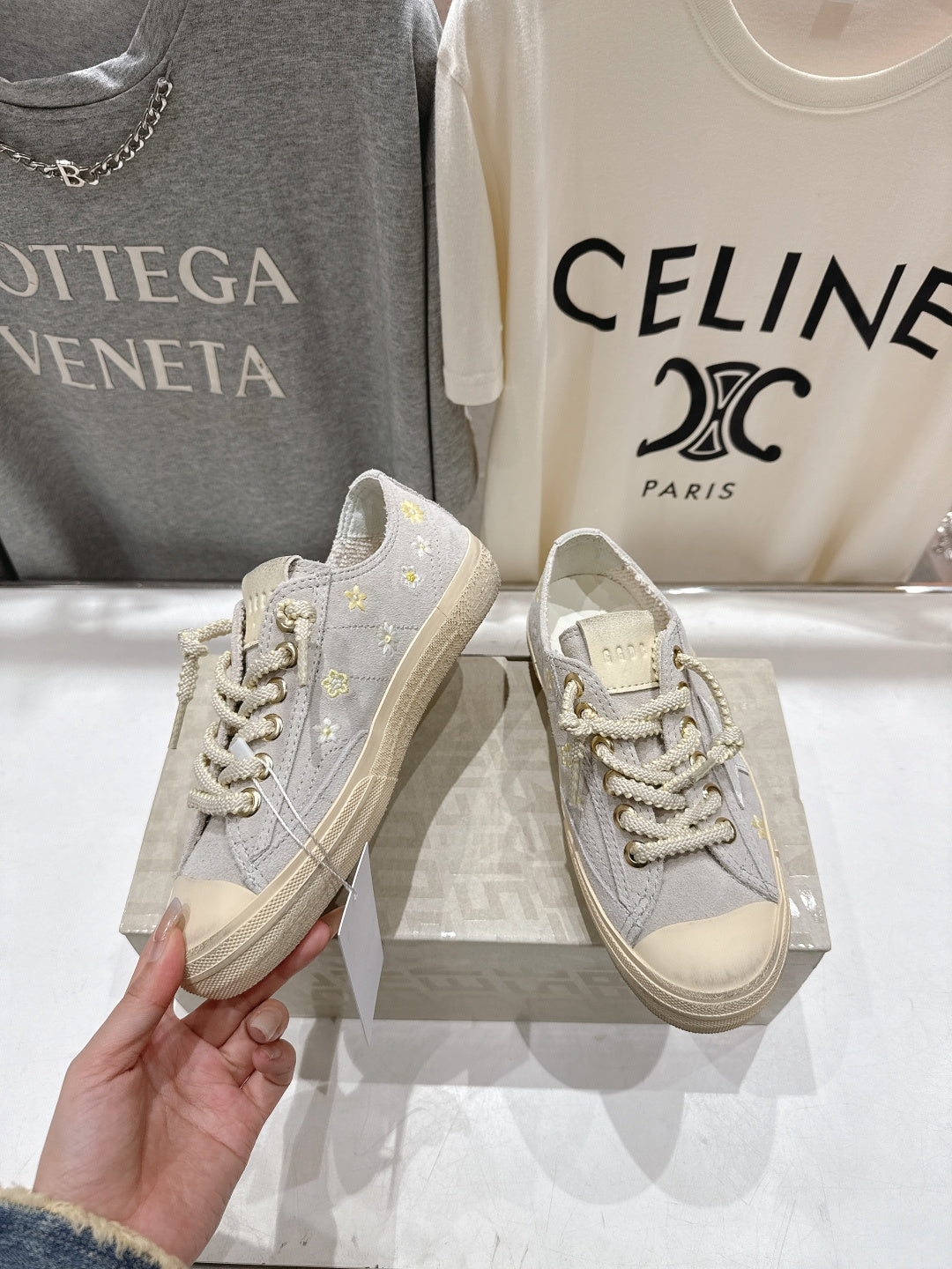 Grey low-top sneakers with gold star accents and white laces, beige sole