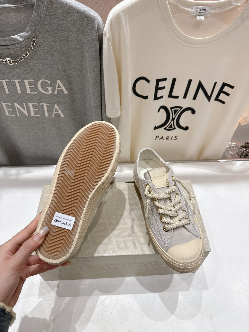 Grey low-top sneakers with beige tread outsole, white lace-up front