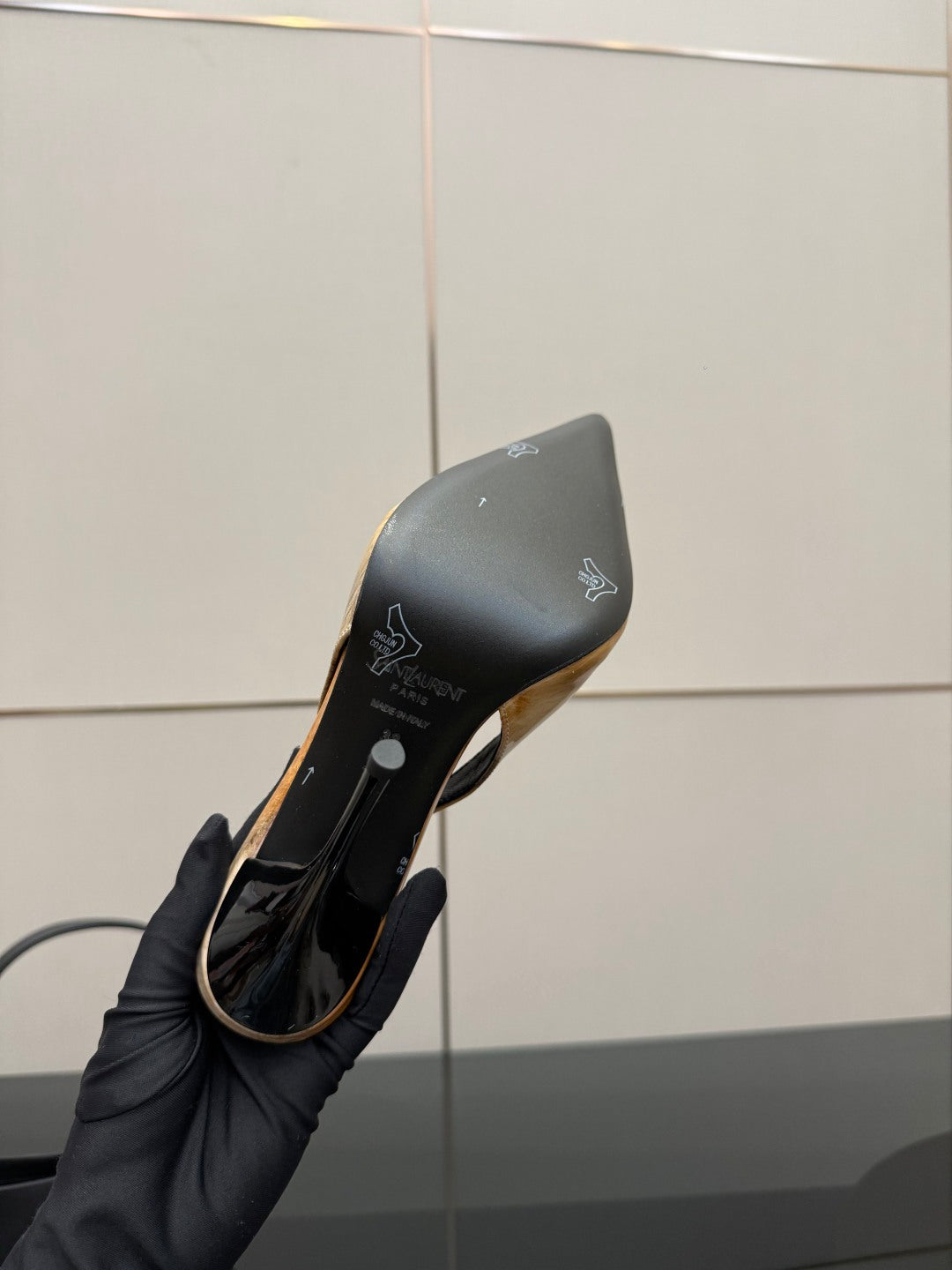Women’s slingback heel underside, black sole with light tan trim and logo print