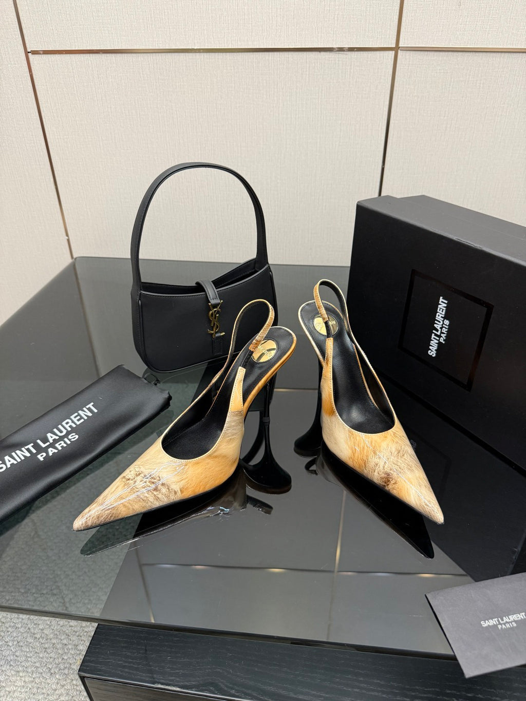 Women’s pointed-toe slingback heels pair with black handbag, gold logo hardware