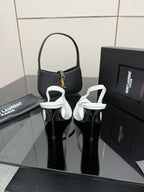 Black pointed-toe stiletto heels with ankle strap and slim heel
