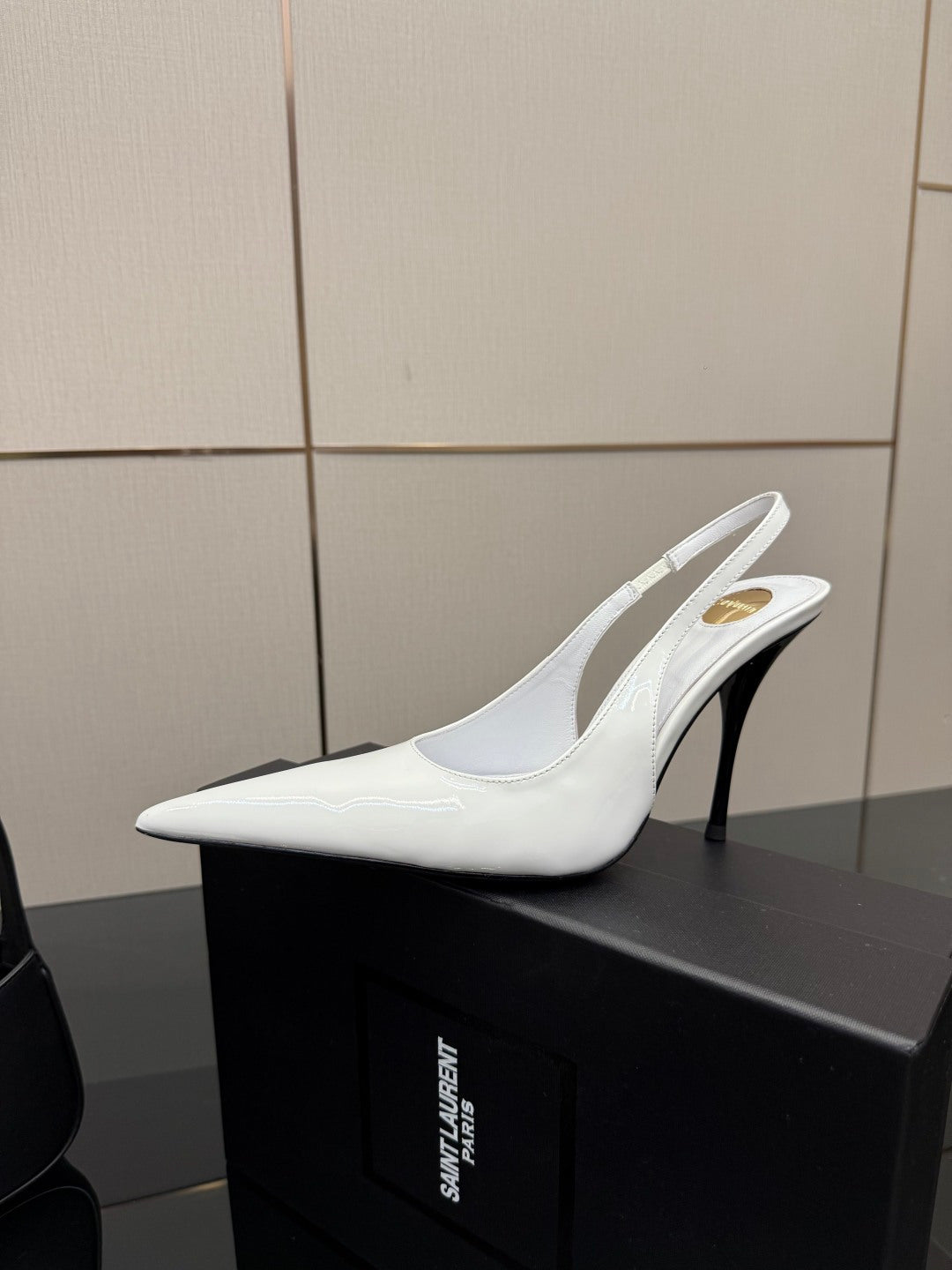 White pointed-toe slingback stiletto heel shoe on box, glossy finish