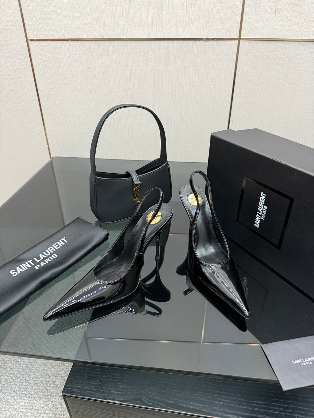 Pair of black patent pointed-toe stiletto heels with thin high heel and strap