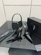 Pair of black patent pointed-toe stiletto heels with thin high heel and strap