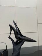 Black patent pointed-toe stiletto heels with ankle strap and glossy shine