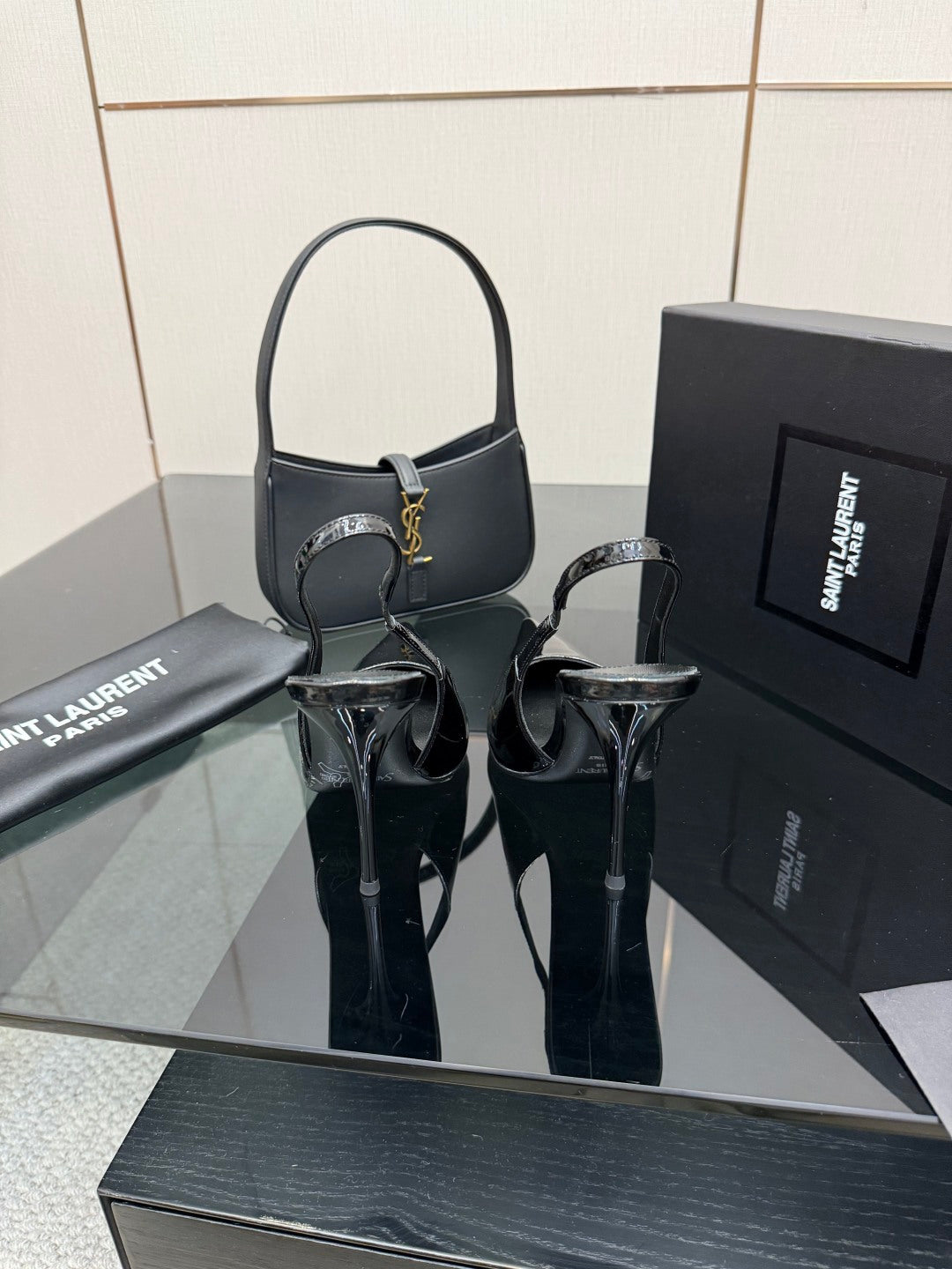 Black patent pointed-toe stiletto heels with ankle strap and high slender heel