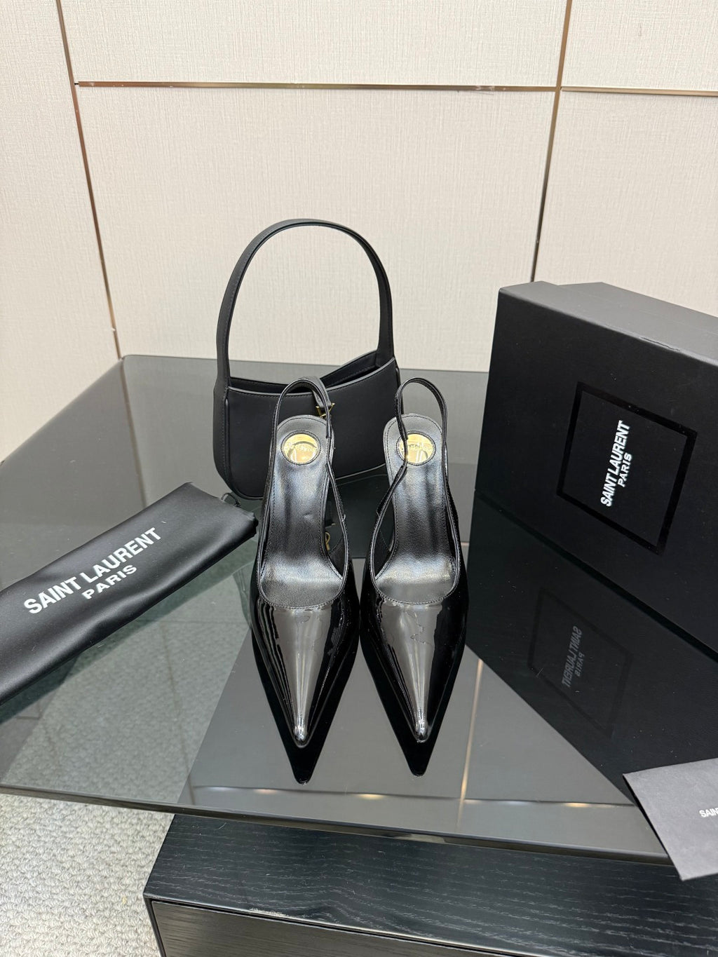 Black patent pointed-toe stiletto heels, high glossy finish with ankle strap