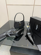 Black patent pointed-toe stiletto heels, glossy surface and ankle strap