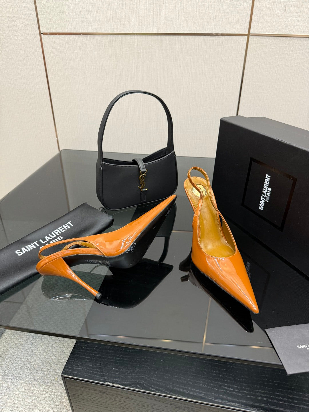 Orange patent pointed-toe slingback heels with slim stiletto heel, angled view