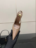 Nude patent leather slingback stiletto heel with gold-tone logo hardware, side view