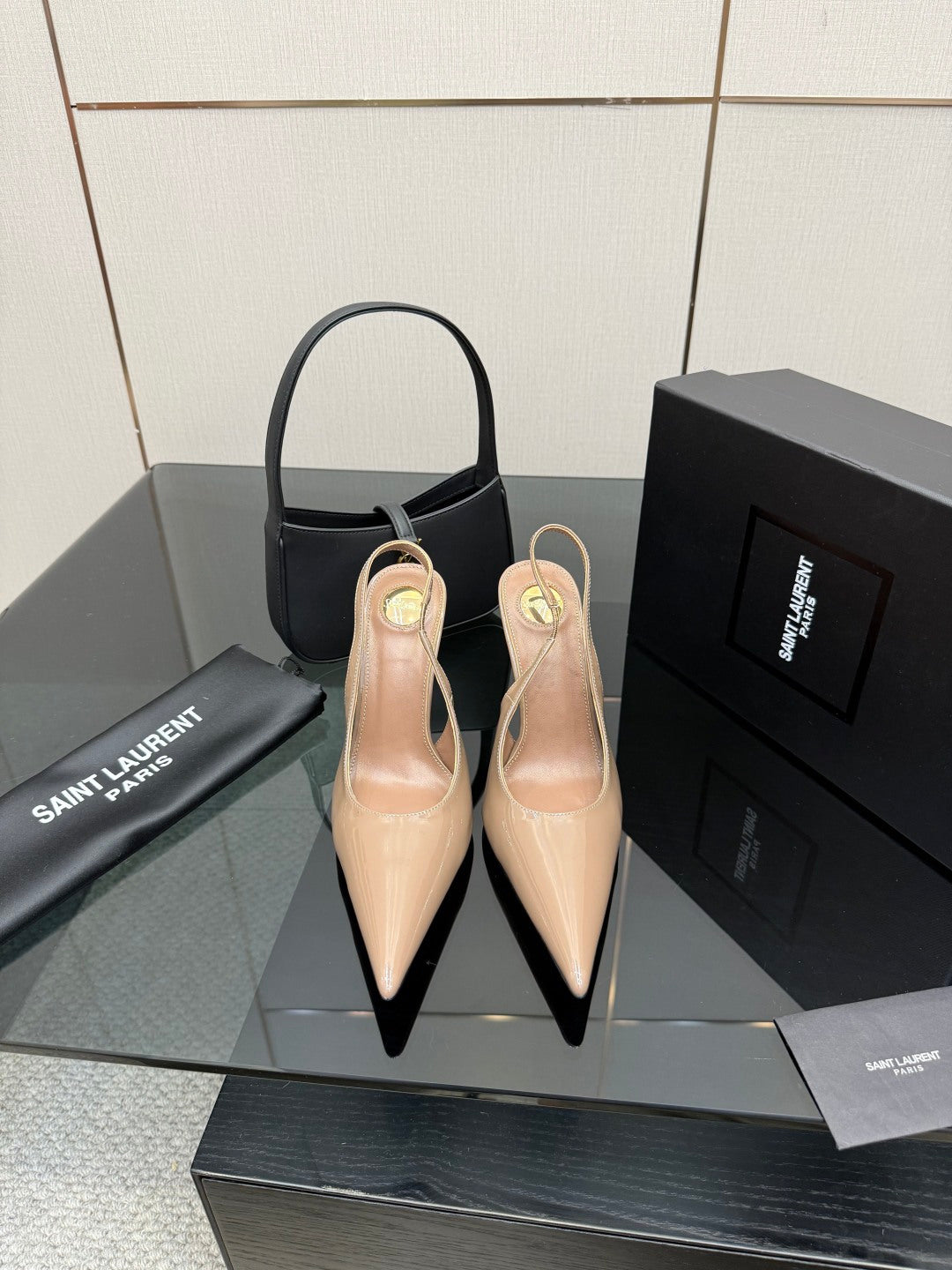 Nude patent leather pointed-toe stiletto heels with gold-tone YSL emblem, pair