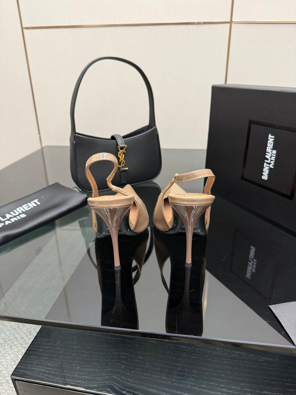 Nude patent leather pointed-toe stiletto heels with ankle strap and gold-tone emblem