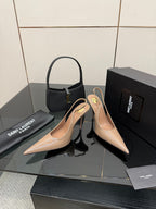 Nude patent leather pointed-toe stiletto heels with gold-tone logo detail, front view